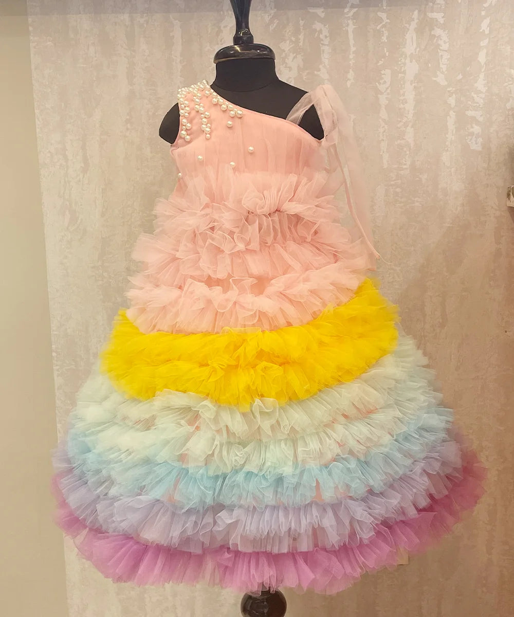 It’s a beautiful ruffle gown, a perfect children birthday dress as well as girls wedding outfit. It features a beautiful pearl detailing on the shoulder that uplifts the entire look. Moreover, it comes with a matching fabric belt to be tied at the back.