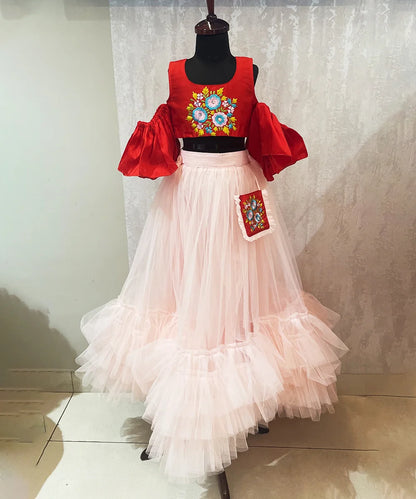 It’s a red and peach Colored ruffle crop-top skirt set that comes with the back zip closure and is a perfect marriage party dress for girl. It features floral patchwork on a crop top and an attached mini bag on the waist of the skirt.