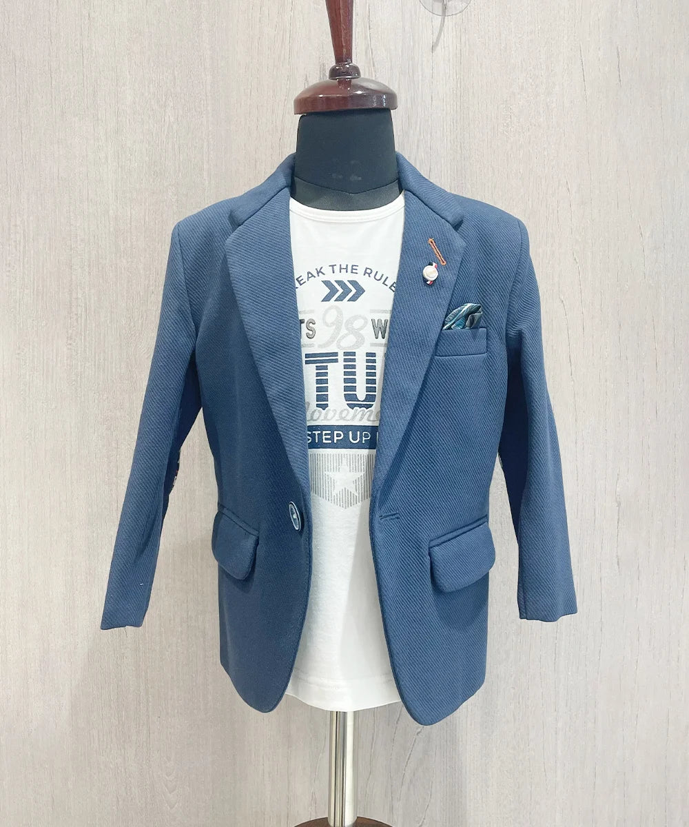 This blazer set consists of a blazer and white Colored T-shirt. It is a perfect wedding wear for boys. It features a broach, printed pocket square and elbow patch detailing on sleeves that adds grace to the look.