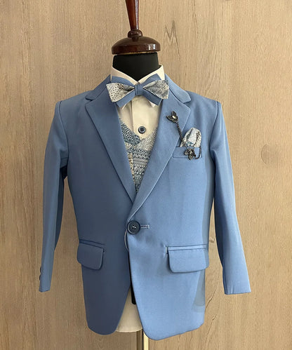 This coat suit for boys consists of a coat, matching pants, a self-printed waistcoat, and a white Colored shirt. It features a matching printed bow, a broach and a printed pocket square.