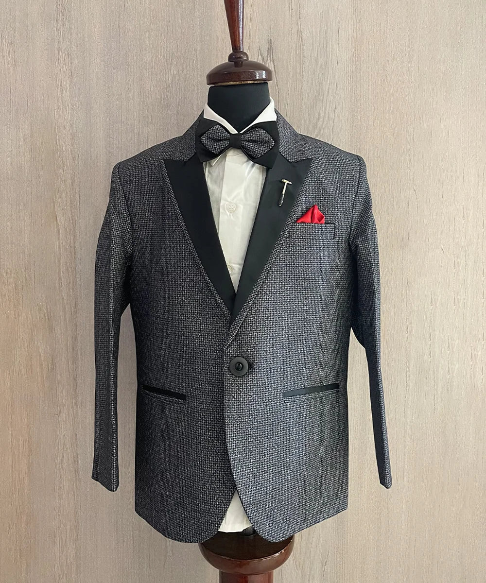 Suits for kid boy consists of a self-textured coat, matching pants and a white Colored shirt with pin tucks detailing on it. It features a matching striped bow, a broach and a red coloured pocket square.