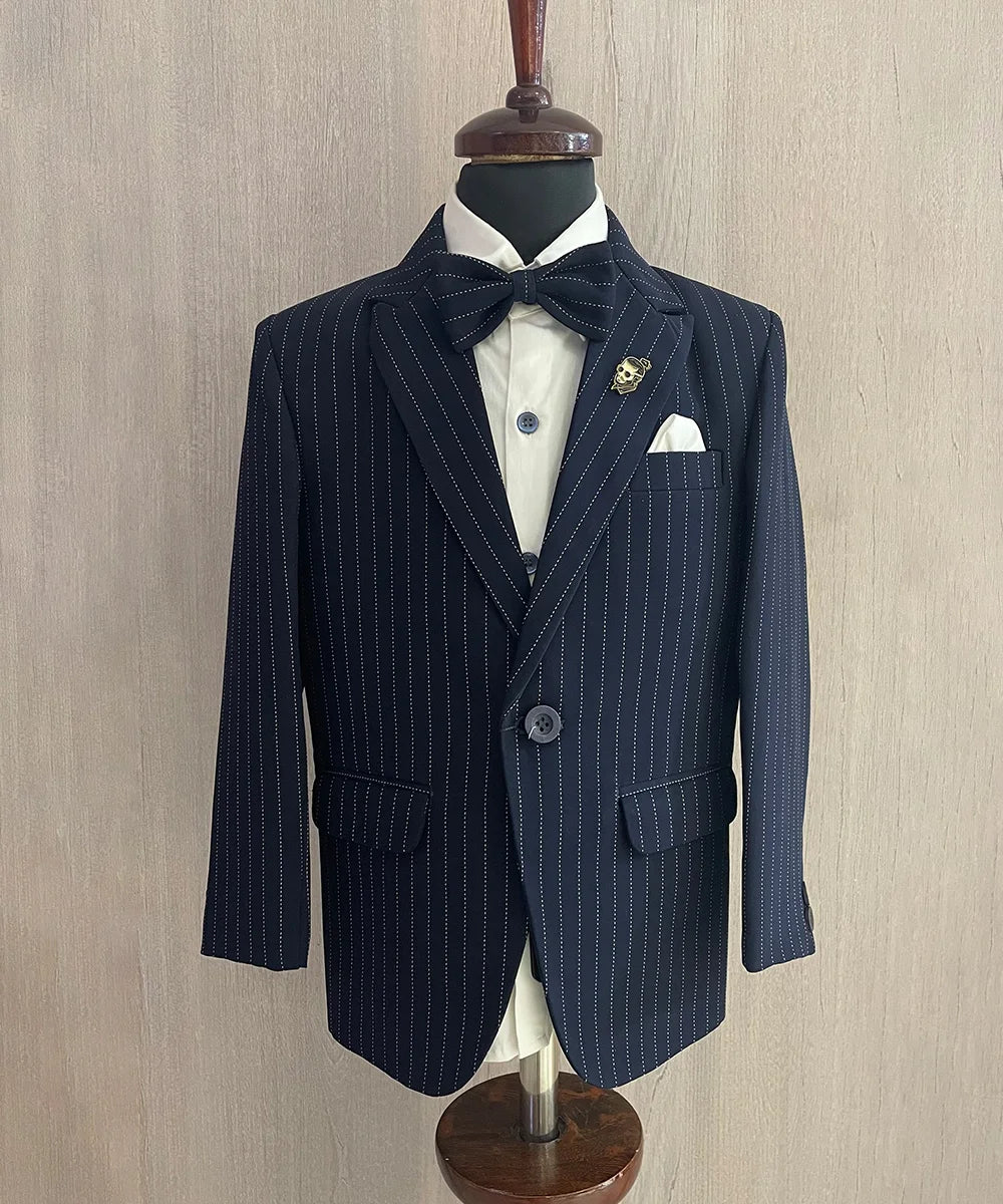 It consists of a self-striped coat, matching pants and a white Colored shirt. It features a matching striped bow, a broach and a white coloured pocket square that uplifts the entire look.