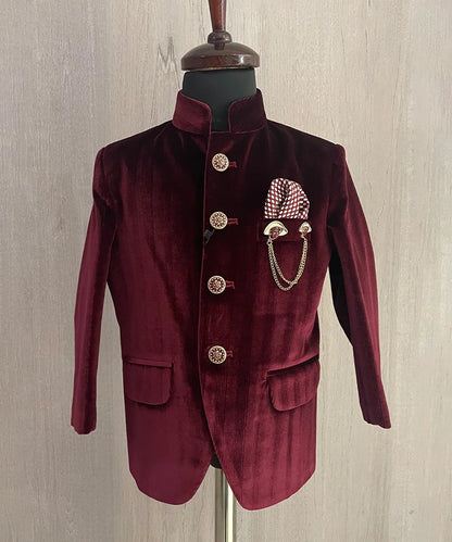 This party dress for boys consist of a Jodhpuri coat and matching black pants. It features a cute broach, a printed pocket square and stylized buttons that add grace to the look.