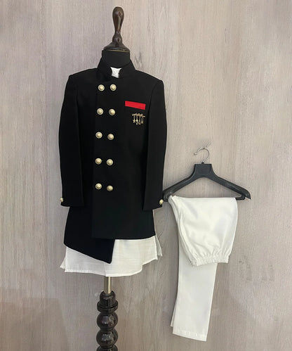 This wedding dress for small boy consists of an asymmetric achkan, white Colored kurta and pyjama. It features a broach and red pocket square that adds grace to the look.