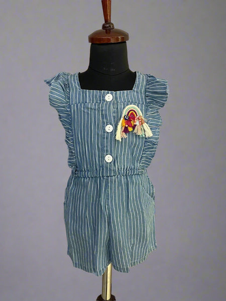  It's a blue colored jumpsuit that comes with an elasticated waist. There is a patchwork of rainbow and some frill detailing too. Moreover, there are 4 pockets on the dress.