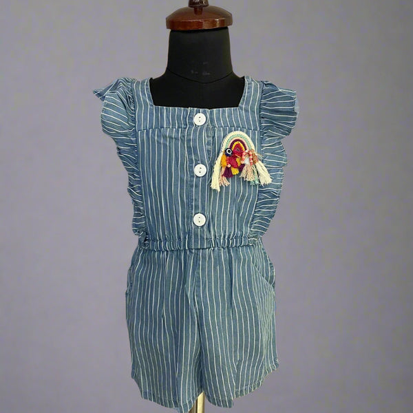  It's a blue colored jumpsuit that comes with an elasticated waist. There is a patchwork of rainbow and some frill detailing too. Moreover, there are 4 pockets on the dress.