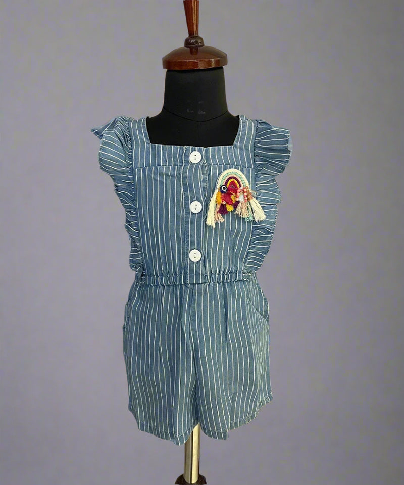  It's a blue colored jumpsuit that comes with an elasticated waist. There is a patchwork of rainbow and some frill detailing too. Moreover, there are 4 pockets on the dress.