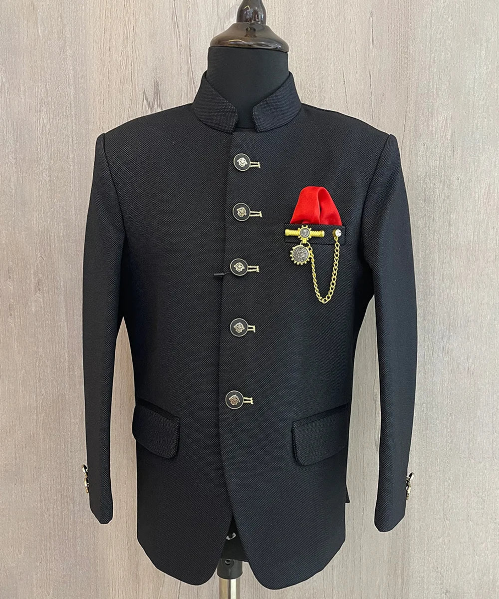  It is a black Jodhpuri suit set which consists of a Jodhpuri Coat along with matching pants. Special Feature: It features stylised buttons, a red coloured pocket square and a nice broach.