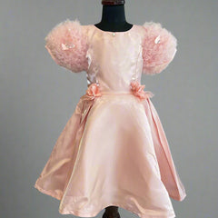 This is a beautiful peach colored kids birthday wear frock for little girls. It features cute floral detailing on the waist. Moreover, it features a pearl detailing that adds grace to the look.