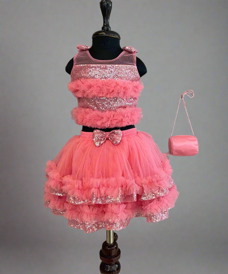  This  pink dress consists of a crop top that comes with a back hook closure and a layered skirt. It is paired up with a matching handbag. It features bow detailing on the shoulder and on the waist. Moreover, there are frill detailings on the dress that elevates the whole look.