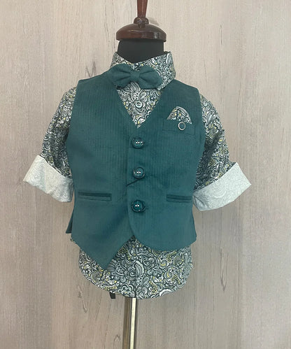 This Green party dress for boys consists of a Waistcoat, a matching pants and a printed shirt. It features a cute broach, a printed pocket square and a matching bow.