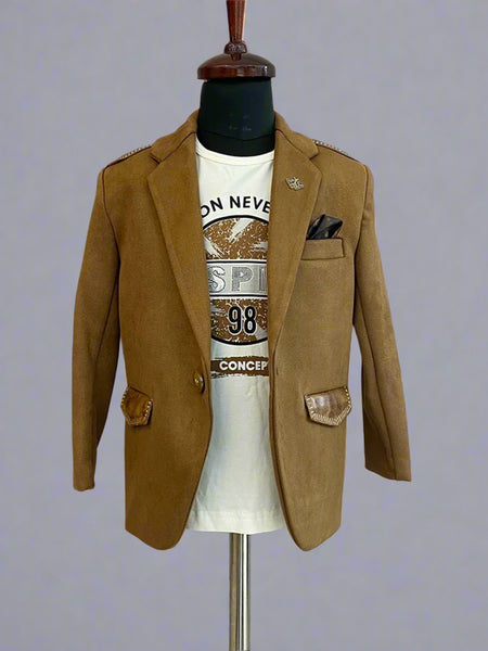 This boys wedding outfit consists of a Tan Brown Colored Blazer and a matching self-printed white Colored t-shirt. It features a cute broach, a printed pocket square and leather detailing on the blazer that adds to the look.