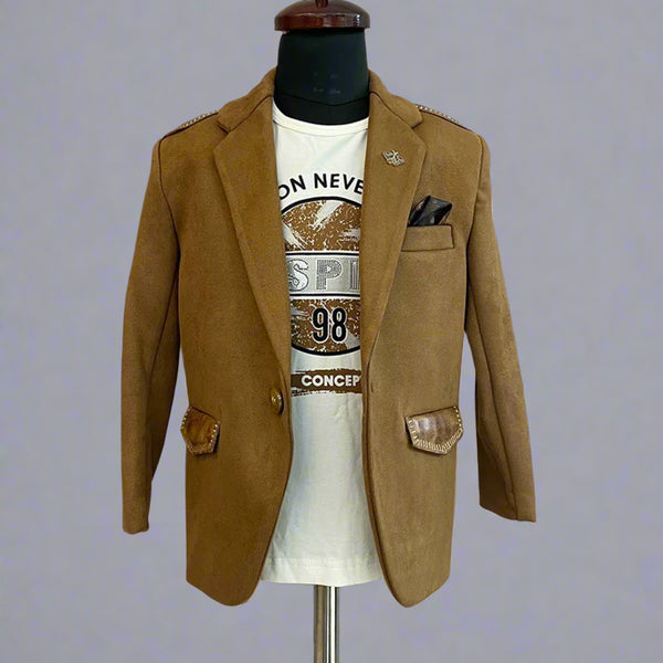 This boys wedding outfit consists of a Tan Brown Colored Blazer and a matching self-printed white Colored t-shirt. It features a cute broach, a printed pocket square and leather detailing on the blazer that adds to the look.