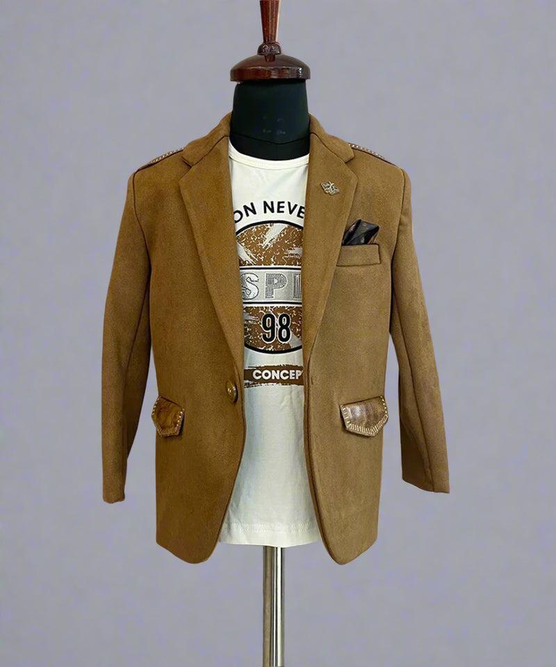 This boys wedding outfit consists of a Tan Brown Colored Blazer and a matching self-printed white Colored t-shirt. It features a cute broach, a printed pocket square and leather detailing on the blazer that adds to the look.
