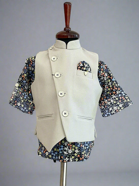 This boys party clothes set consists of a cream coloured waistcoat, matching pants and a self-printed blue Coloured shirt. It features a cute broach and a printed pocket square that uplifts the entire look.