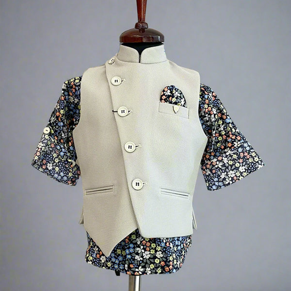This boys party clothes set consists of a cream coloured waistcoat, matching pants and a self-printed blue Coloured shirt. It features a cute broach and a printed pocket square that uplifts the entire look.