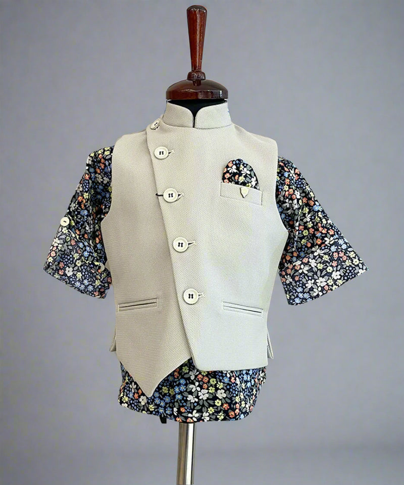 This boys party clothes set consists of a cream coloured waistcoat, matching pants and a self-printed blue Coloured shirt. It features a cute broach and a printed pocket square that uplifts the entire look.