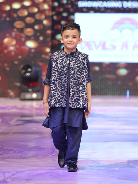 Child wearing a navy blue color kurta pyjama with a nehru jacket with shimmer work.