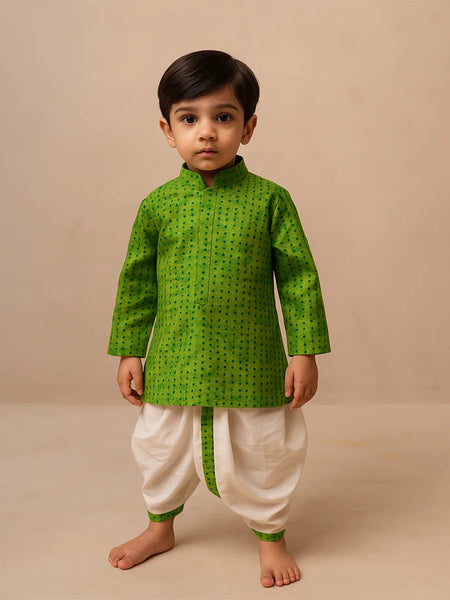 Child wearing a green kurta with white dhoti on a beige background