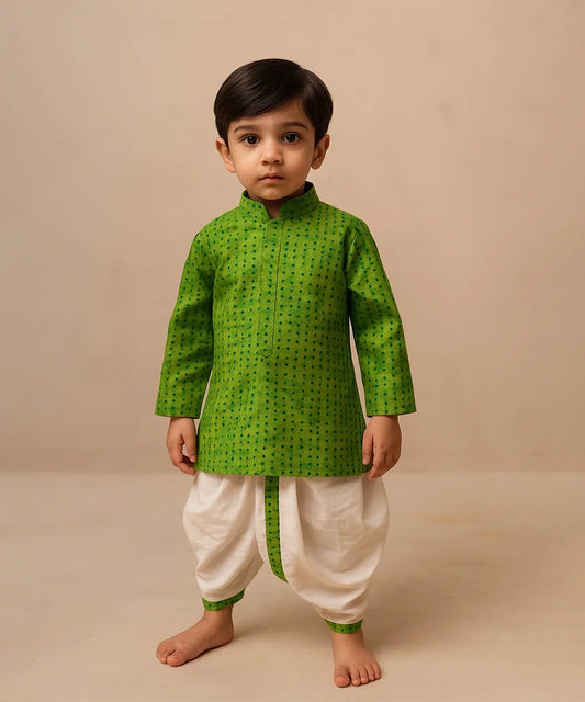 Child wearing a green kurta with white dhoti on a beige background
