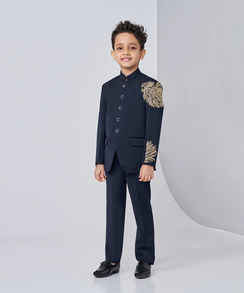 Child wearing a formal black suit with gold accents on a white background