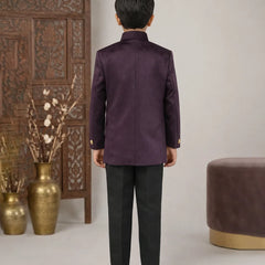 Person wearing a purple traditional outfit standing in a room with decorative elements.