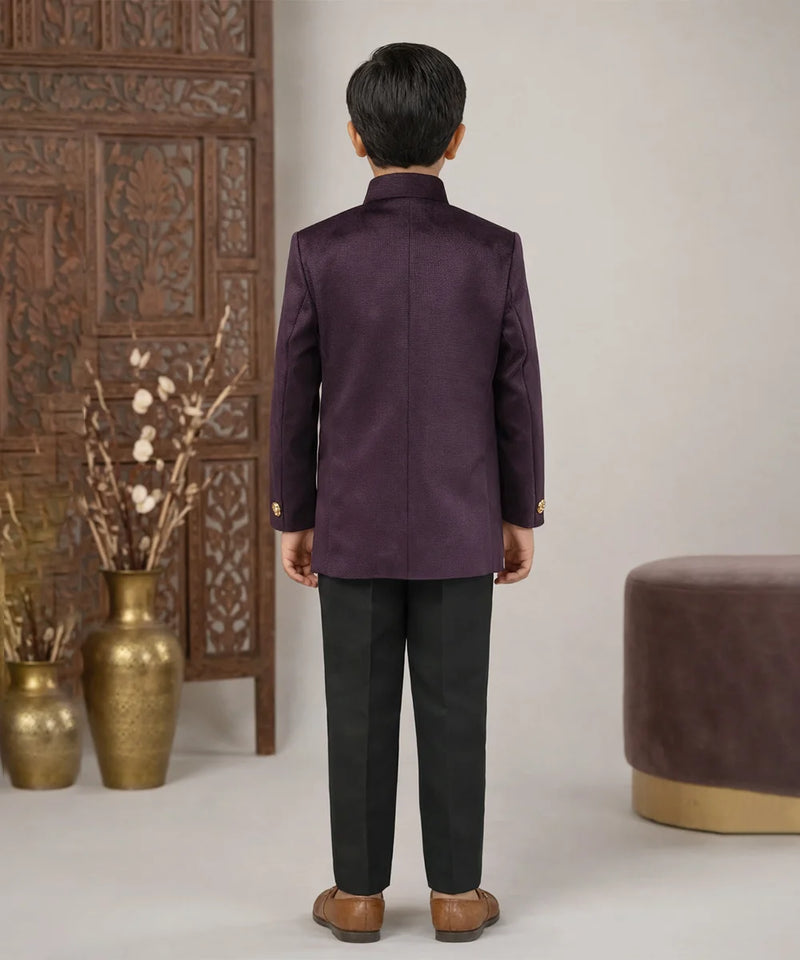 Person wearing a purple traditional outfit standing in a room with decorative elements.