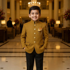 Young boy in a formal outfit standing in an elegant hallway with chandeliers and floral arrangements.