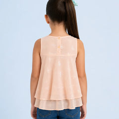 Back view of a person wearing a peach layered top and blue jeans on a light blue background