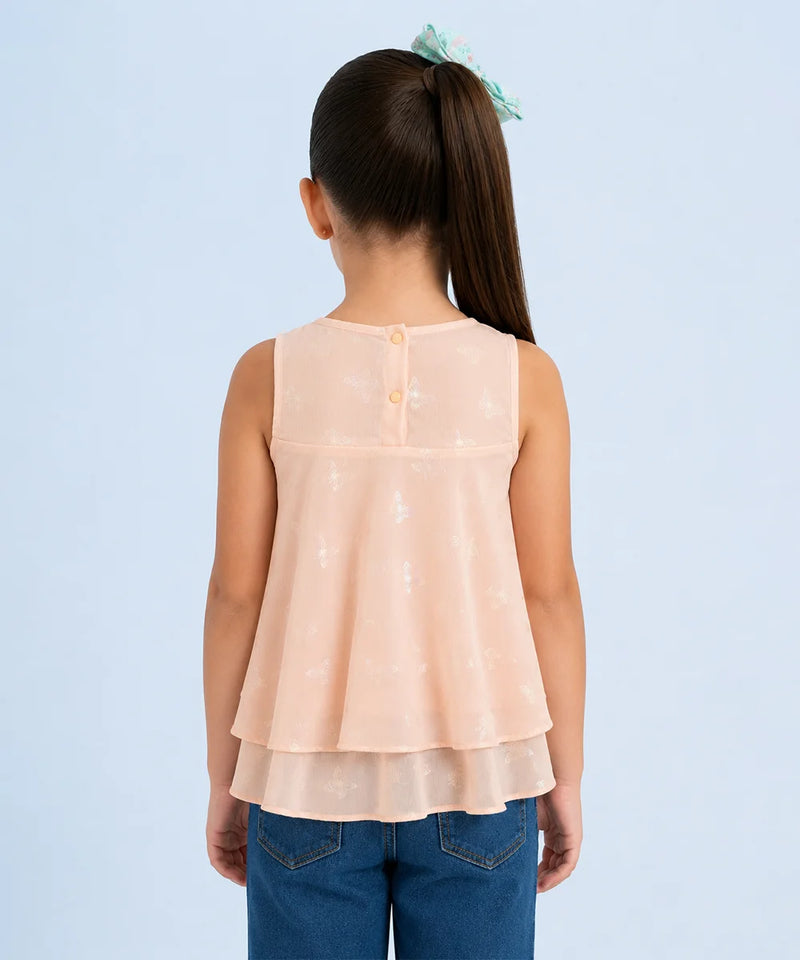 Back view of a person wearing a peach layered top and blue jeans on a light blue background