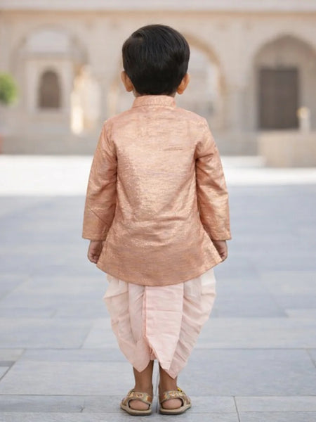 Child wearing a traditional outfit standing in an outdoor setting with arches in the background.