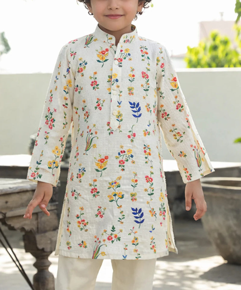 Child wearing a floral printed kurta with a white background