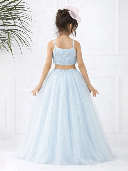 Young girl wearing a light blue two-piece dress with a white background