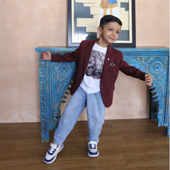 This boys wedding outfit consists of a Maroon Colored Blazer and a matching self-printed white Colored t-shirt. It features a small broach, a printed pocket square and elbow patch detailing that uplifts the entire look.