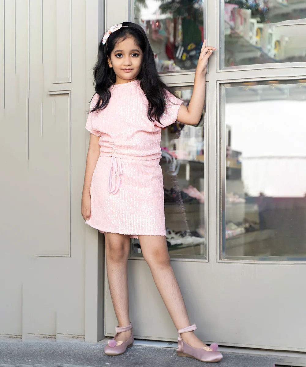 This peach Colored dress consist of a top with a back closure and a skirt for little girls. The top has a beautiful Tie-String Knot feature that gives it a stylized look.