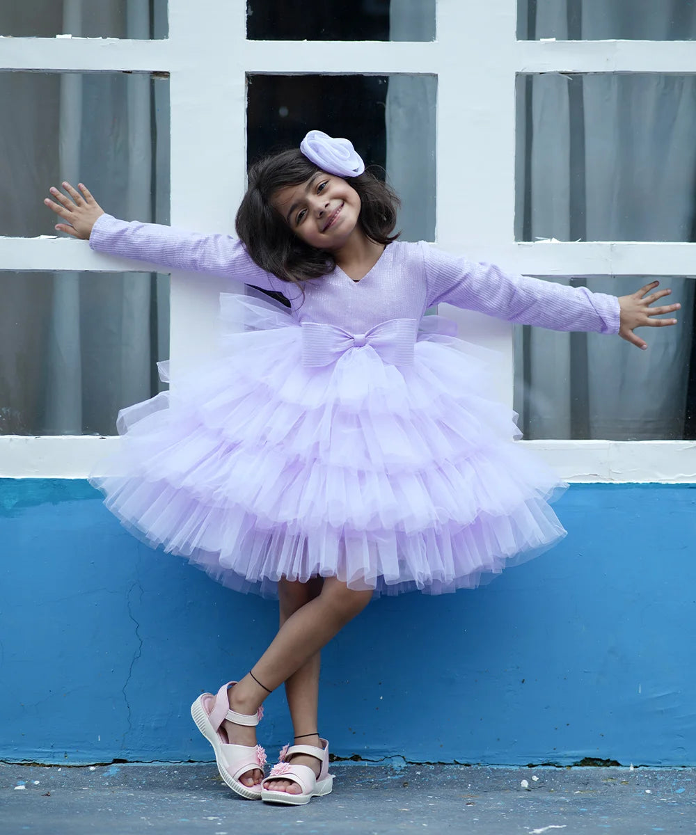  It’s the lavender shimmer frock for girls with a back hook closure. It features a big front bow curated from sequin fabric, matching hair pin and a fabric belt to be tied at the back.