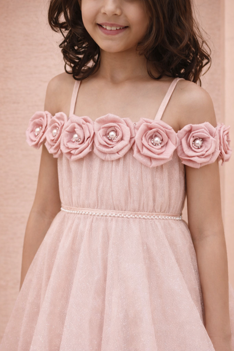 Pink dress with floral embellishments on a pink background