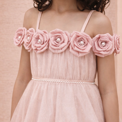 Pink dress with floral embellishments on a pink background