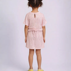 Young girl wearing a pink dress with a white background