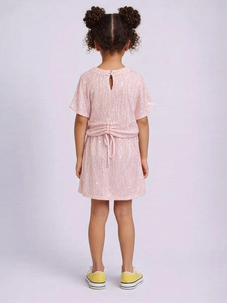 Young girl wearing a pink dress with a white background