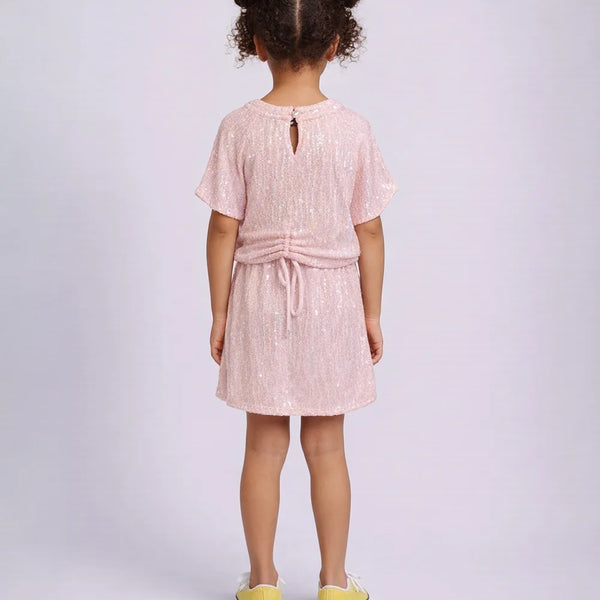 Young girl wearing a pink dress with a white background