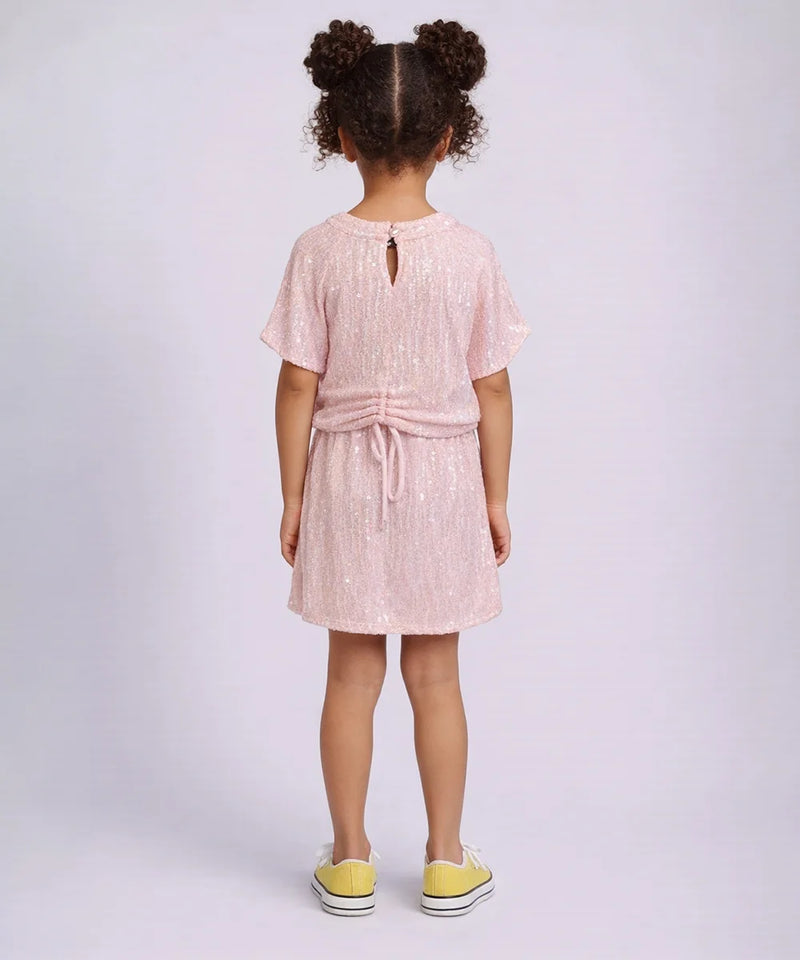 Young girl wearing a pink dress with a white background