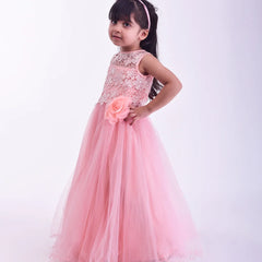 Young girl in a pink dress holding a flower against a white background