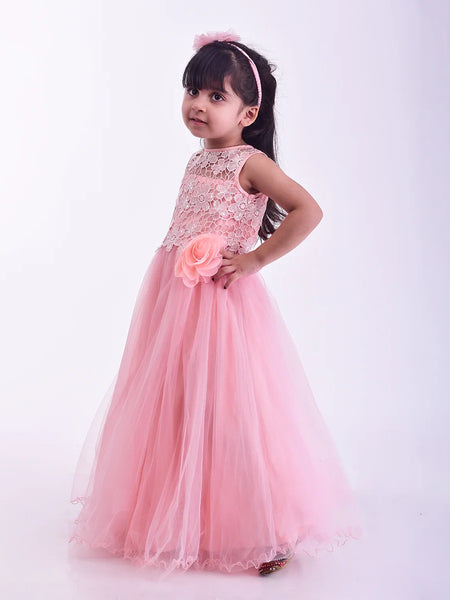 Young girl in a pink dress holding a flower against a white background