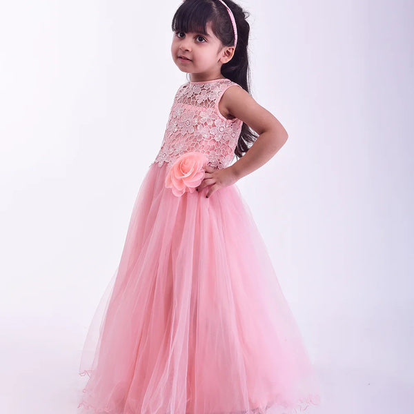 Young girl in a pink dress holding a flower against a white background