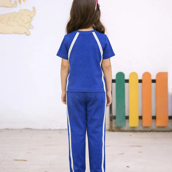 Child wearing a blue tracksuit with white stripes in a classroom setting