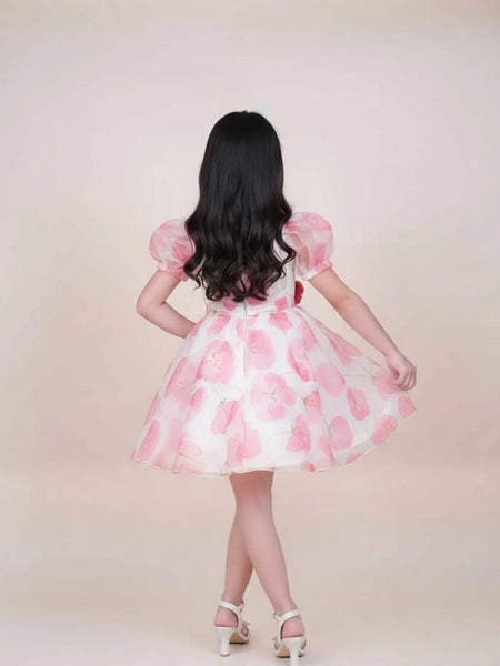 girl wearing a pink and white dress with puffed sleeves on a beige background