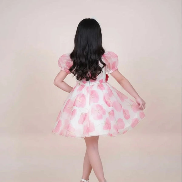 girl wearing a pink and white dress with puffed sleeves on a beige background