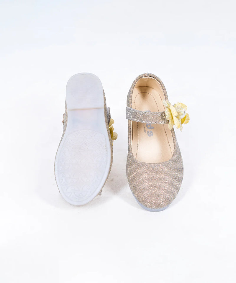 Close-up of girls' gold party flats with yellow flower detail and secure strap, Jaipur