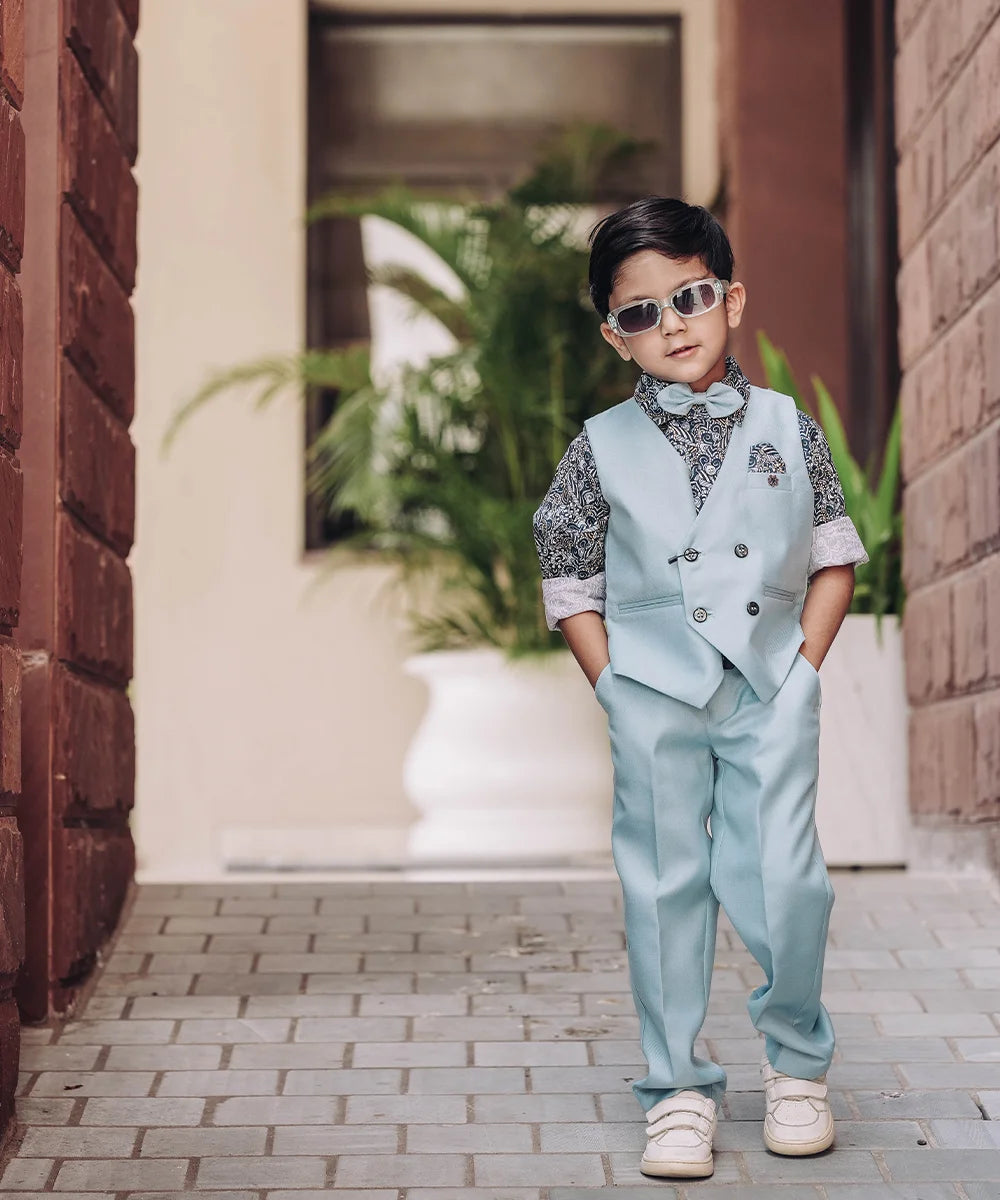  This party dress for boys consists of a Waistcoat, a matching pant and a printed shirt. It features a cute broach, a printed pocket square and a matching bow that adds grace to the look.